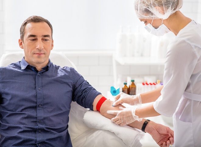 Skillful nurse is doing blood test for man in clinic